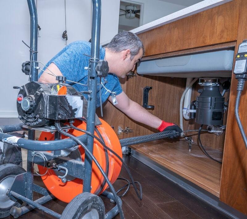 A plumber clearing a drain