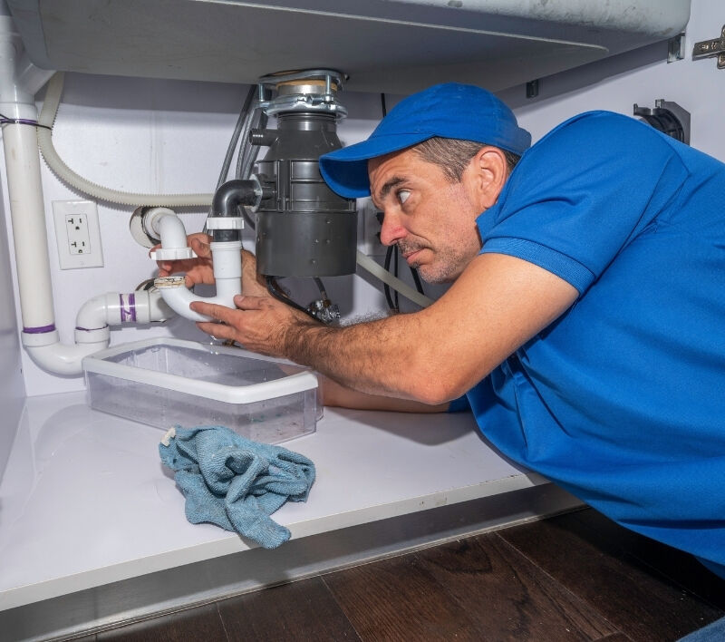 Plumber repairing a leaking pipe