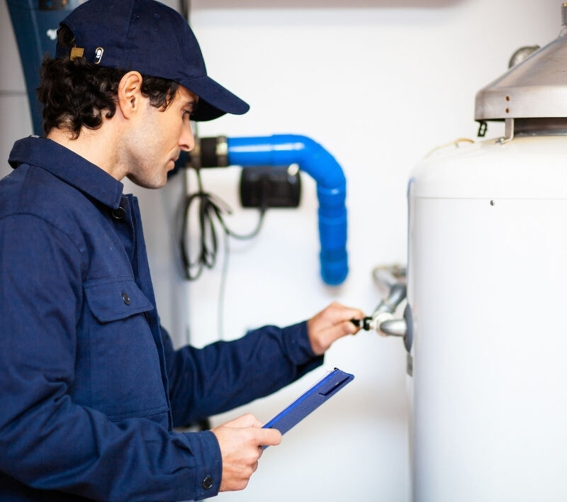 A plumbing technician working on a water heater